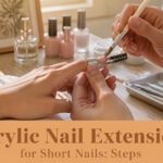 Acrylic nail extensions on short nails displayed in a stylish beauty setting.