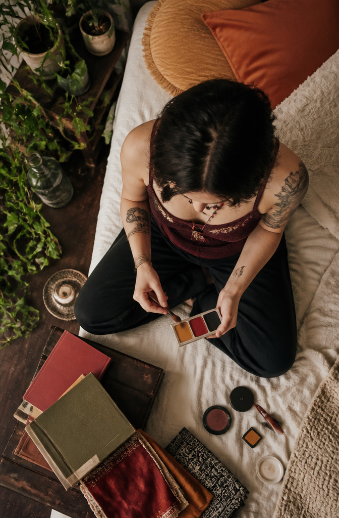 How to Do Easy Alt Makeup: 6 Steps for Alternative Looks in 2026 9 Makeup palette displaying red, black, and ochre shades on a table.